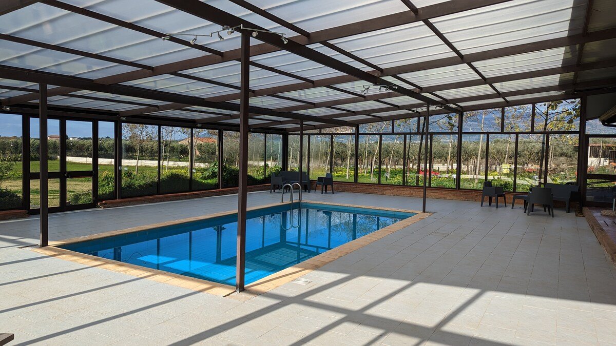 Piscina coperta della Fattoria Il Laghetto con vetrate affacciate sull'uliveto