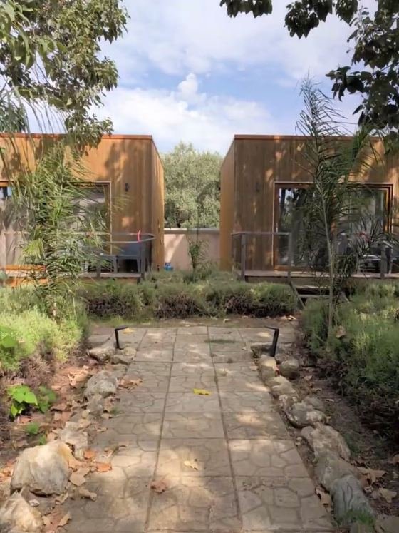 Il vialetto in pietra che porta ai due bungalow Cubo House, fra le piante del giardino